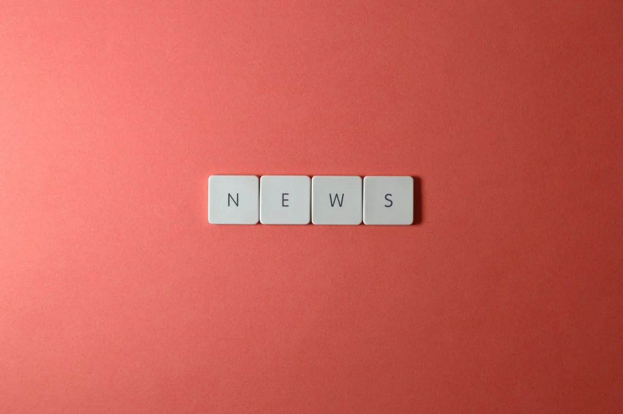 Close-up of keyboard keys spelling NEWS on a red background, minimalist style.